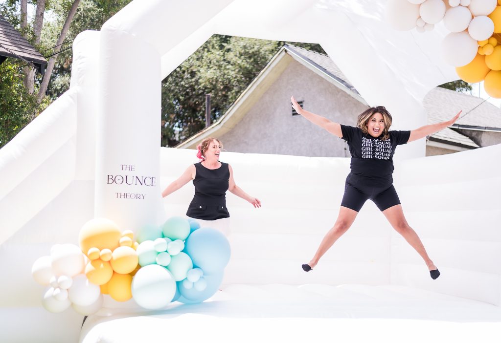 2 people jumping in a large bounce house